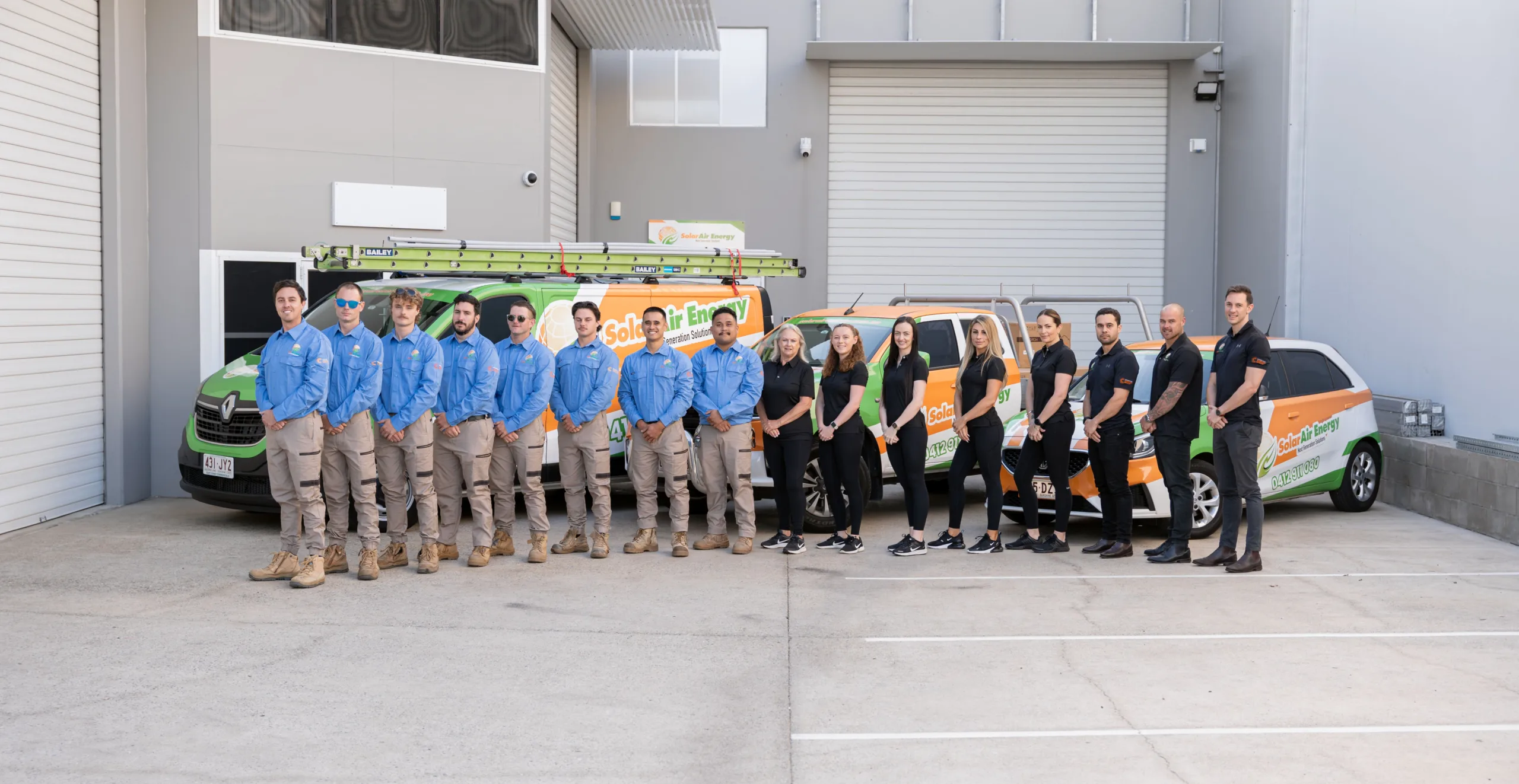 Solar Air Energy team photo in front of company vans.